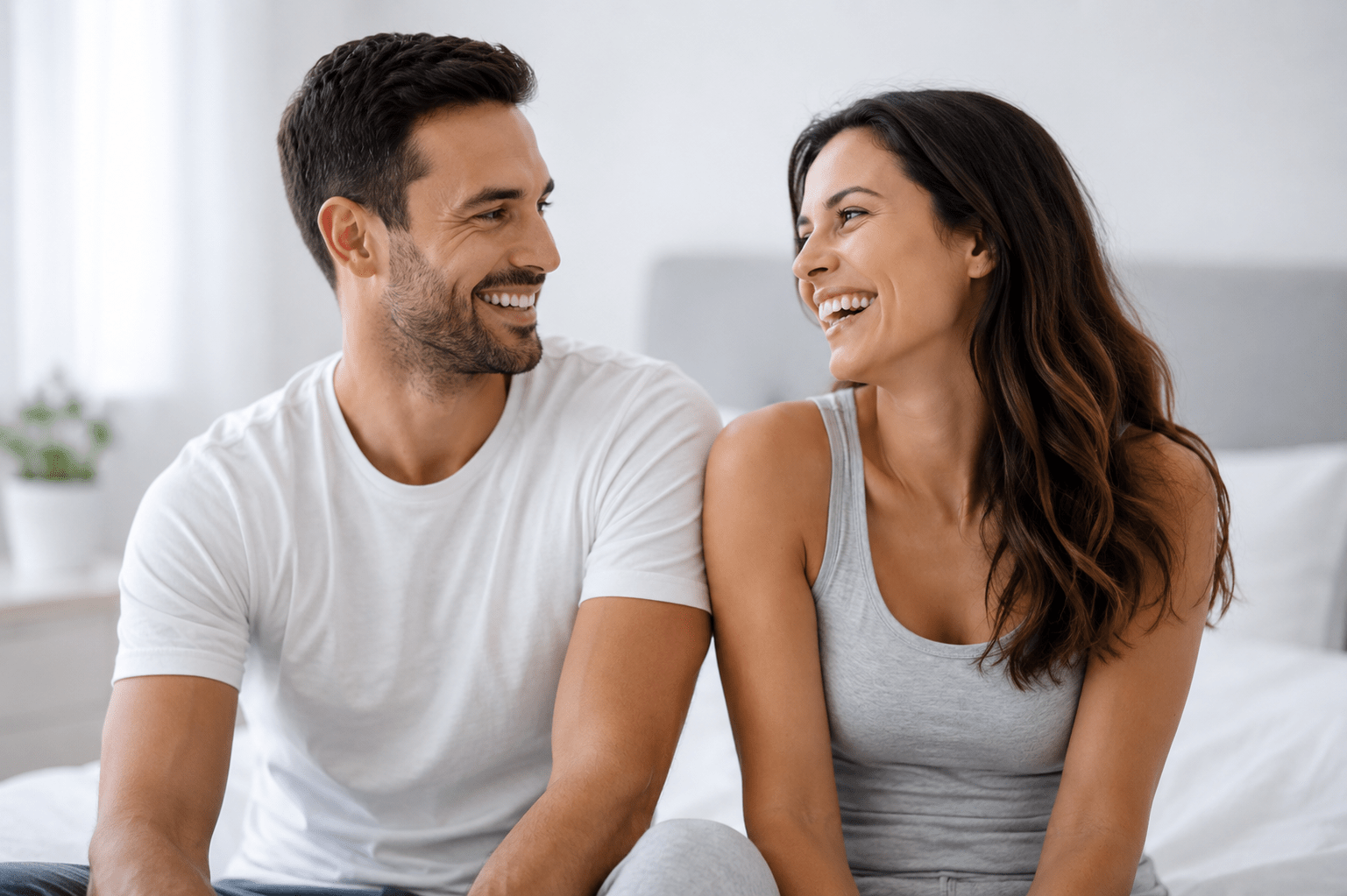 Two people sitting closely together indoors in a relaxed setting.