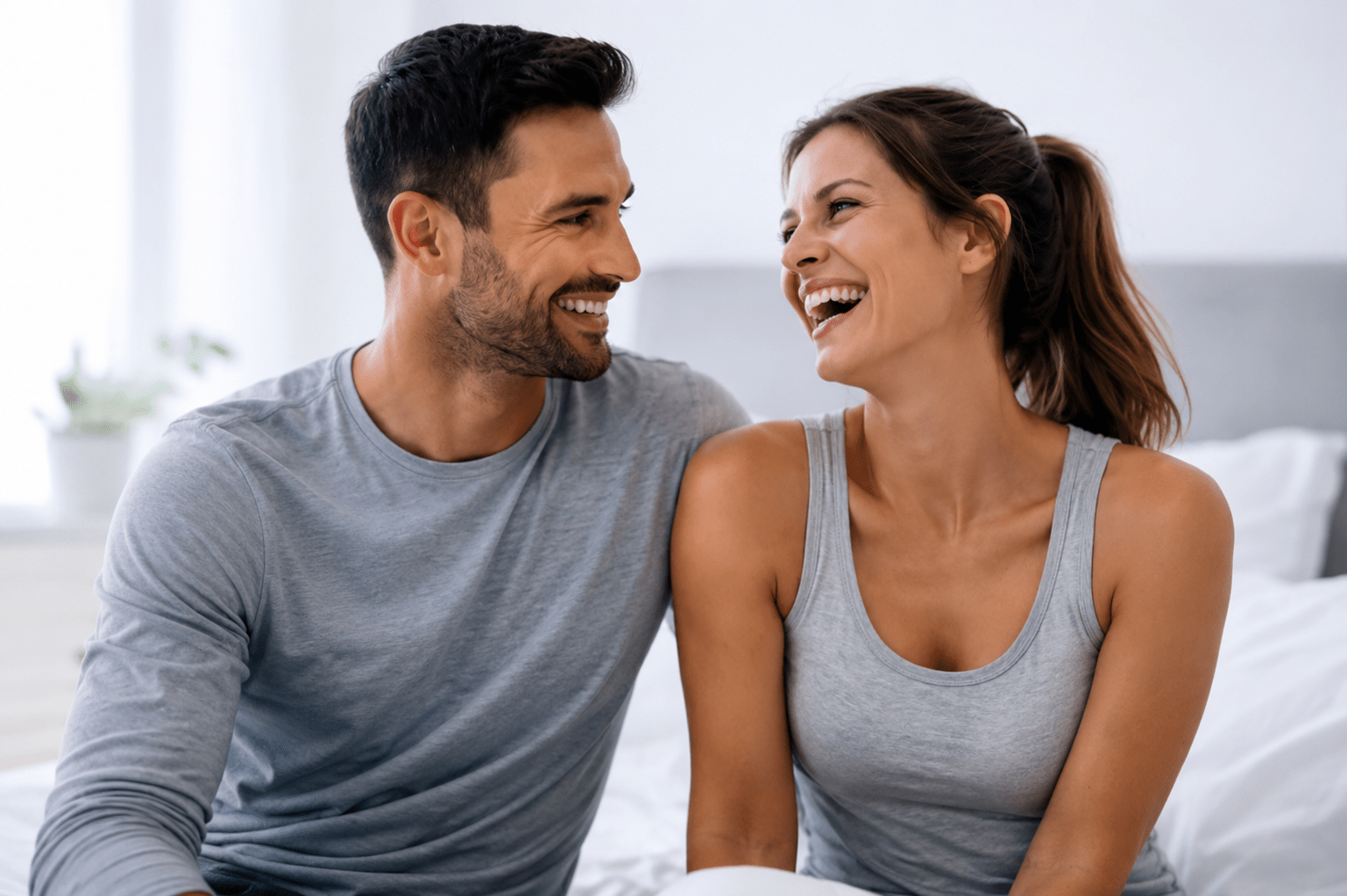 Two people sitting closely together indoors in a relaxed setting.